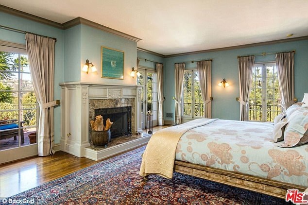 Phòng ngủ lớn dành cho chủ nhà có lò sưởi và tầm nhìn đẹp, mở ra quang cảnh vùng đồi.