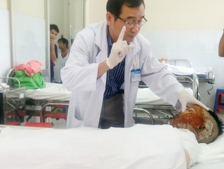 Bị tạt a xít, thiếu nữ nguy cơ mù cả 2 mắt - 2 BS Ngô Đức Hiệp kiểm tra thị lực cho bệnh nhân với tiên lượng rất xấu