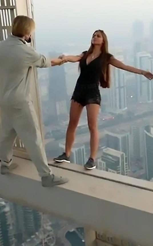 Liều mạng tạo dáng trên nóc nhà cao tầng để chụp ảnh Instagram - 1
Viki nắm tay trợ lý rồi ngửa người ra ngoài tòa nhà cao hơn 300m