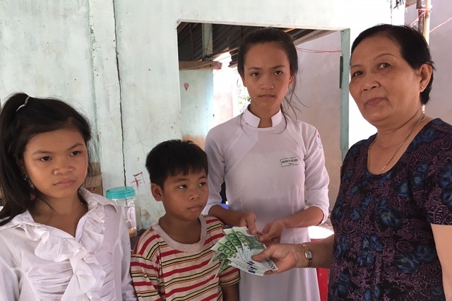 Hơn 200 triệu đồng đến với 5 chị em mồ côi - 3 Bà Mai Thị The đại diện thân nhân nhóm Việt kiều sinh sống tại Đức trao tiền cho mấy chị em mồ côi
