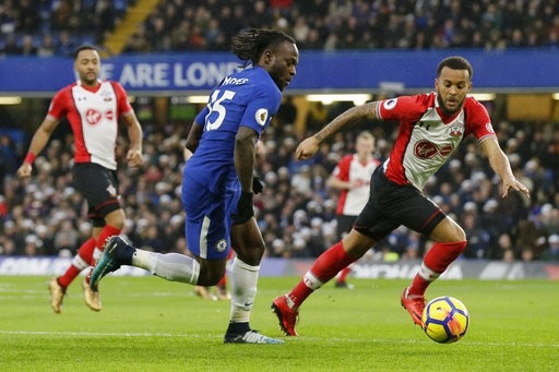 
Moses (giữa) đẩy bóng trước sự truy cản của Redmond (phải)
