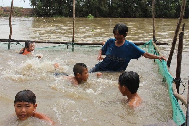 Bà bán vé số dạy bơi miễn phí cho trẻ được tôn vinh là phụ nữ tiêu biểu toàn cầu - 1 Bà Trần Thị Kim Thia dạy bơi cho trẻ vùng lũ. (Ảnh: Nguyễn Hành)