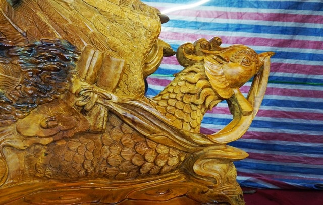 Chiêm ngưỡng bộ bàn ghế “tứ linh” bằng gỗ trai nghìn năm giá gần 3 tỷ đồng - 6 Tay vịn cuối ghế là hình con chim phượng hoàng như đang vỗ cánh bay lên