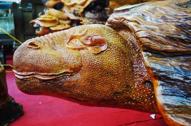 Chiêm ngưỡng bộ bàn ghế “tứ linh” bằng gỗ trai nghìn năm giá gần 3 tỷ đồng - 7 Chiếc bàn hình con rùa được tạo từ gỗ trai nghìn năm tuổi nguyên khối. Phía trước là đầu con rùa...