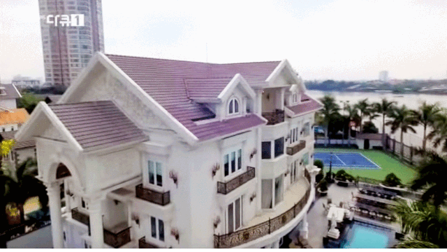 Choáng với loạt biệt thự dát vàng, chung cư triệu đô la của nhà sao Việt - 1
Đoạn phóng sự của Đài truyền hình KBS Hàn Quốc về bố chồng của nữ diễn viên Tăng Thanh Hà khiến công chúng choáng ngợp khi quay tại chính dinh thự dát vàng của gia đình. Khán giả nhanh chóng nhận ra đây chính là nơi Đàm Vĩnh Hưng và các học trò từng ghi hình. Biệt thự ba mặt tiền nằm ở vị trí cực đẹp ngay gần bên con sông Sài Gòn. Ngôi nhà với màu trắng sang trọng nổi bật, ước chừng rộng 500m2, bao quanh ngôi nhà là một hàng cây xanh. Bên trong biệt thự còn có sân tennis, bể bơi. (Ảnh: cắt từ video).