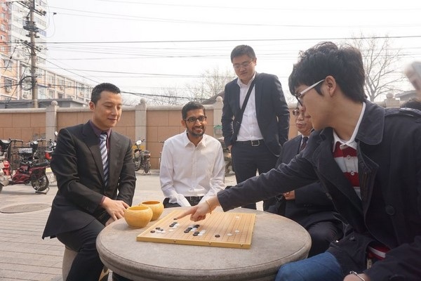 Trí tuệ nhân tạo sẽ vượt qua trí tuệ con người trong trận đấu đáng mong đợi? - 1 Ke Jie (ngoài cùng bên phải) đang giải thích về “vẻ đẹp” của cờ vây với CEO Sundar Pichai của Google (người mặc áo sơ mi trắng)