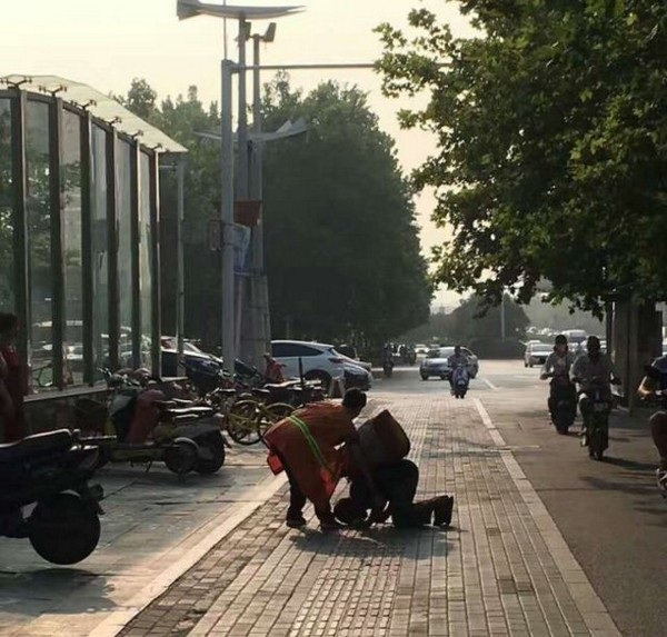 Hình ảnh người quét rác chia bữa ăn cho người ăn xin mù khiến cộng đồng mạng cảm động - 2 Người ăn xin mù quỳ xuống đất để bày tỏ sự biết ơn với người nữ lao công