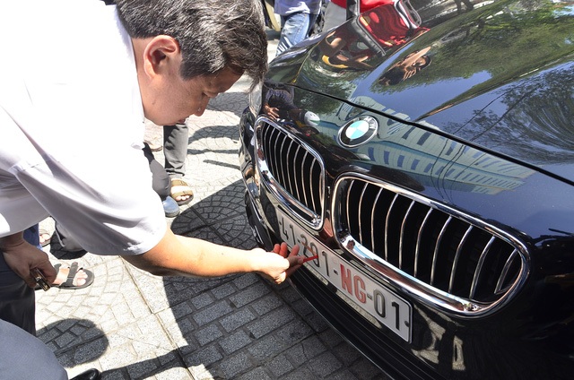 Xác định chiếc xe biển số ngoại giao có vi phạm, tuy nhiên nhân viên Sở Ngoại vụ TPHCM thông báo đây là chiếc xe của ngài Tổng lãnh sự Hungari nên ông Đoàn Ngọc Hải - Phó Chủ tịch UBND quận 1 TPHCM đã đồng ý tháo niêm phong, không cẩu xe về đồn mà chỉ lập biên bản xử phạt số tiền 700 ngàn đồng với tài xế. (Ảnh: Đình Thảo)