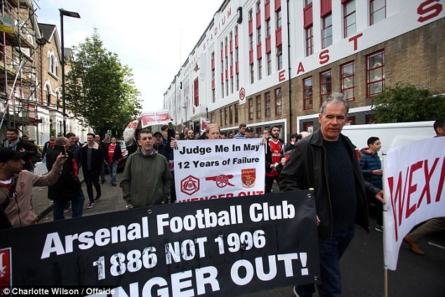 CĐV Arsenal mang theo biểu ngữ kêu gọi HLV Wenger ra đi trước trận đấu với MU