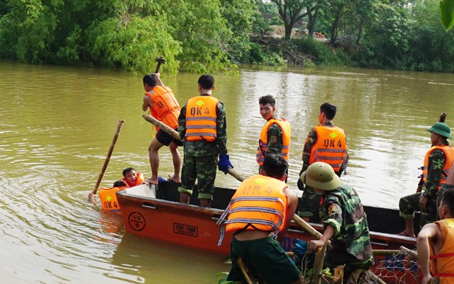 Vật lộn trong lũ chèn đá hộc, đóng cọc gia cố chân đê - 2 Lực lượng quân sự đóng cọc kè cách chân đê khoảng 10 mét để đổ đá gia cố chân đê. Nước sâu, chảy xiết, thuyền chòng chành khiến việc đóng cọc kè rất khó khăn
