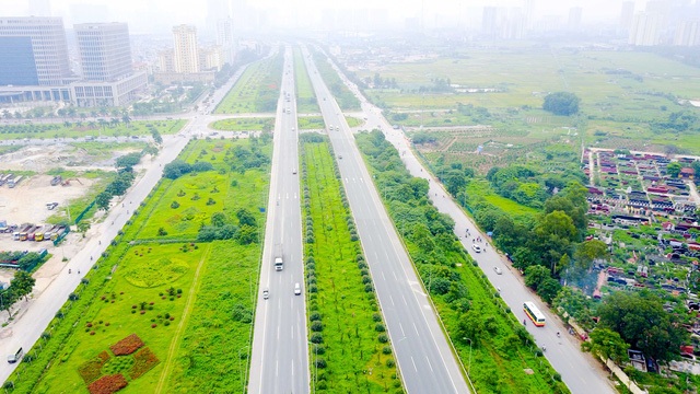Người dân “vượt lũ” trên phố Hà Nội, “quái vật” khổng lồ xuyên lòng đất Sài Gòn - 3 Cỏ, cây dại trên Đại lộ Thăng Long (TP Hà Nội) không được cắt tỉa mọc um tùm, tràn cả ra lề đường. Nhiều đoạn, cây dại trùm lên cả dải phân cách, làm mất tác dụng của đèn phát quang báo hiệu giao thông. (Ảnh: Vũ Toản)