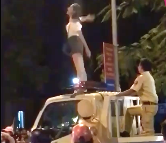 Cô gái trèo lên nóc xe CSGT nhảy múa la hét - 1 Cô gái trèo lên nóc xe lực lượng CSGT nhảy múa (ảnh cắt từ clip)