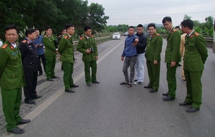 Đối tượng tông xe làm chết Trung tá CSGT bị khởi tố tội giết người - 1 Hoàng Văn Trường (áo xanh) được dẫn giải đến hiện trường để phục vụ quá trình điều tra.