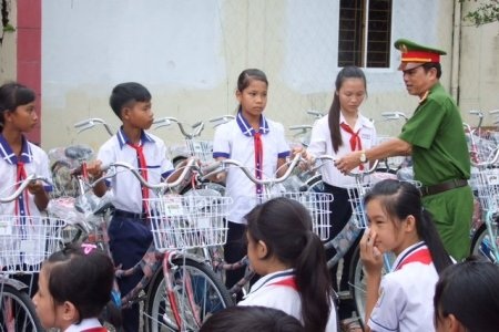 Ấm lòng “Nồi cháo nghĩa tình” của công an dành cho bệnh nhân nghèo - 4 Lãnh đạo Công an huyện Mỹ Tú đang trao quà là xe đạp cho học sinh nghèo.