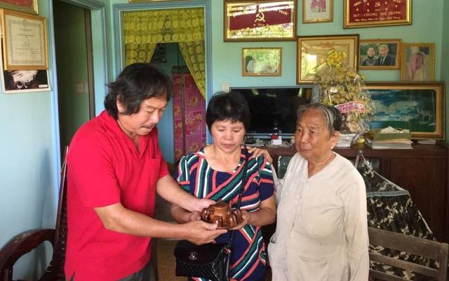 Nhà báo Nguyễn Phấn Đấu và mẹ tặng bà Mi (giữa) một bộ ấm trà làm bằng gáo dừa Bến Tre, với lời nhắn khi về Trung Quốc uống trà, sẽ nhớ về những người Việt Nam thân thiện, biết cảm thông cảm, chia sẻ