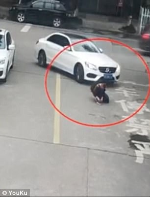 Nam sinh thoát chết dưới gầm ô tô nhờ... đeo ba lô - 1
Ảnh chụp từ clip cho thấy cậu bé ngồi buộc dây giày giữa đường