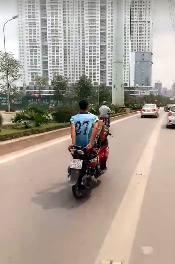 Nam thanh niên lái xe máy bằng chân trên làn đường buýt nhanh - 1 Nam thanh niên trổ tài điều khiển xe máy bằng chân. (Ảnh cắt từ clip)