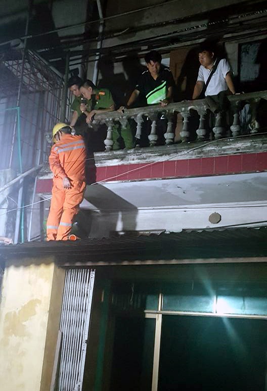 Dây điện chập cháy truyền vào cửa nhà dân, một phụ nữ tử vong - 2 Công an và nhân viên điện lực ghi nhận hiện trường vụ việc.