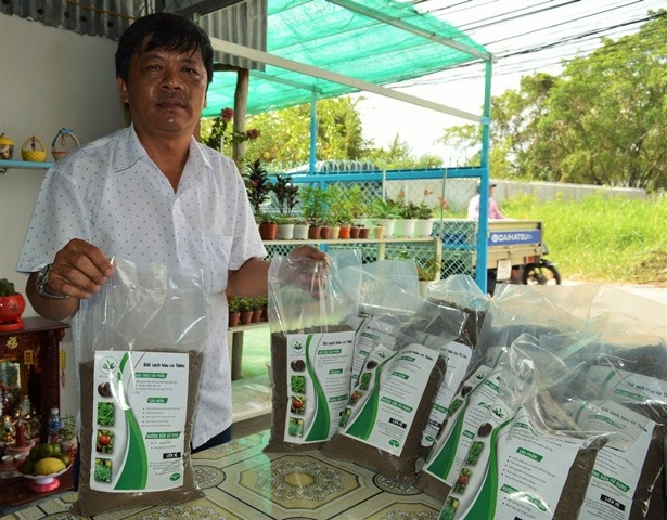 Hai sinh viên chế bùn vi sinh từ chất thải thủy sản để trồng rau sạch - 4 Anh Nguyễn Văn Phong chọn đất sạch hữu cơ của hai em để bón cho rau