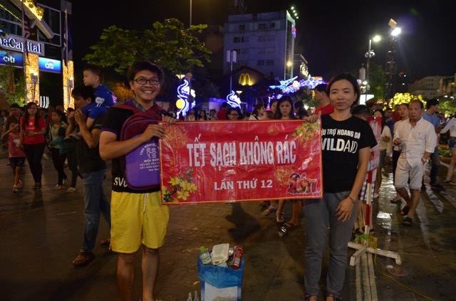 Người dân cả nước hân hoan trong phút giao thừa - 87
Một nhóm sinh viên tình nguyện đứng giữa đường hoa tuyên truyền, vận động người dân không xả rác.