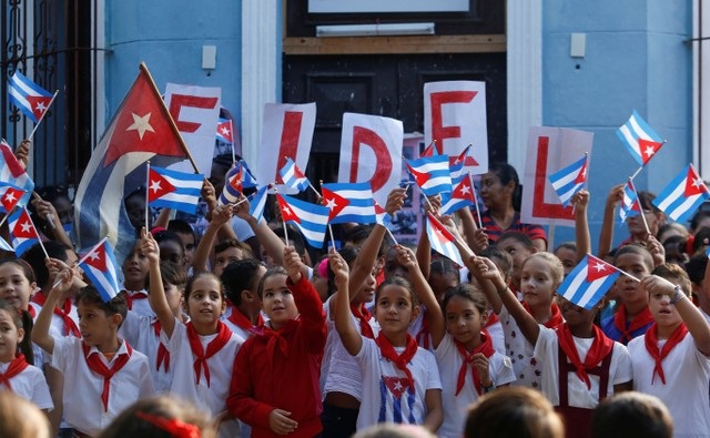 Cuba long trọng tưởng nhớ 1 năm ngày mất lãnh tụ Fidel Castro - 9
Các học sinh giơ cao quốc kỳ và bảng chữ tên lãnh tụ Fidel Castro. (Ảnh: Reuters)