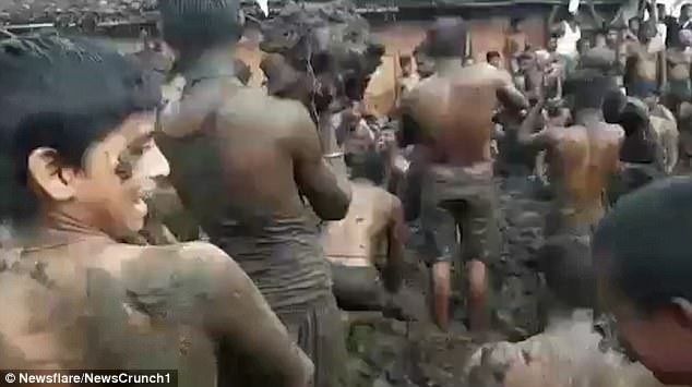 Tục lệ kỳ lạ: Ném phân bò lên người khác để... cầu may - 1 Những người đàn ông trong làng ném phân bò lên người nhau