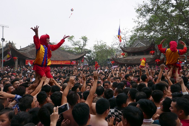 Ảnh tuần qua: Lễ hội đầu năm tưng bừng và... quá tải! - 8 Gần trăm trai tráng phô diễn sức mạnh trong màn phối hợp rước ông đám ở hội pháo Đồng Kỵ (Từ Sơn, Bắc Ninh) diễn ra sáng nay, mùng 4 Tết. Họ là những thanh niên tuổi trên 18 tràn đầy sinh lực tượng trưng cho đoàn quân ra trận đánh giặc, trong lễ hội nổi tiếng nhất nhì đất Kinh Bắc mới được công nhận là Di sản văn hóa phi vật thể quốc gia. (Ảnh: Quý Đoàn)