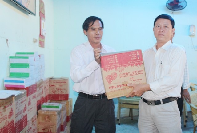 Một người dân bỏ tiền túi trao tặng hàng ngàn cuốn vở cho học sinh nghèo - 1 Ông Nguyễn Văn Định (trái) trao tập đến đại diện các đơn vị trường học để tặng các em học sinh nghèo nhân năm học mới.