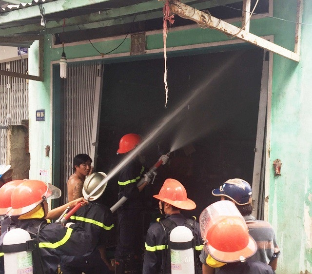 Nhà cụ ông mù 70 tuổi phát cháy giữa trưa - 1 Lực lượng chức năng tỉnh Cà Mau đang phun nước dập lửa trong căn nhà bị cháy. (Ảnh: CTV)