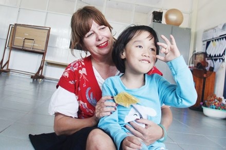 Cảm phục tấm lòng “người mẹ ngoại quốc” của hàng trăm trẻ khuyết tật Việt Nam - 2 Cô Jackie bên một em nhỏ ở Trung tâm Kỳ Anh. (Ảnh: Báo Tiền Phong)