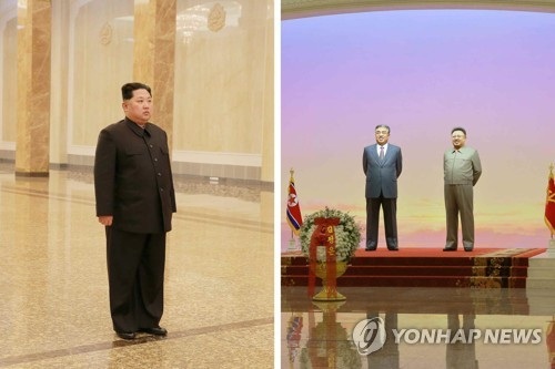 Ông Kim Jong-un tuyên bố đấu tranh vì một Triều Tiên hùng mạnh - 1 Nhà lãnh đạo Triều Tiên Kim Jong-un đứng trước tượng cha và ông nội. (Ảnh: Yonhap)