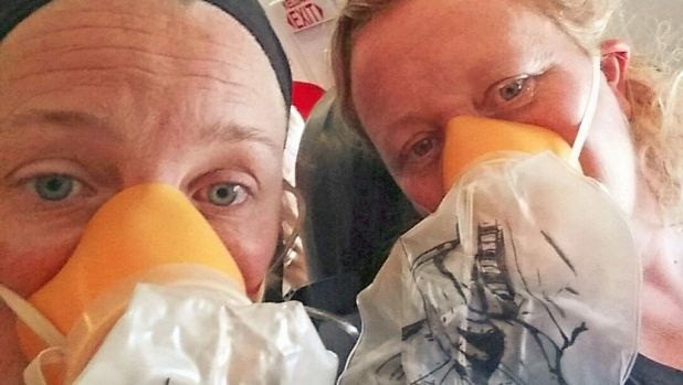 Máy bay chở 145 hành khách hạ cánh khẩn cấp ở Australia - 1 Hai hành khách đeo mặt nạ dưỡng khí khi máy bay AirAsia gặp sự cố ngày 15/10 (Ảnh: SMH)