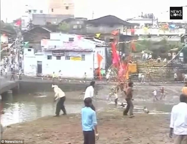 Người dân tụ tập hai bên bờ sông và ném đá về phía những người đang tranh cướp cờ phía dưới