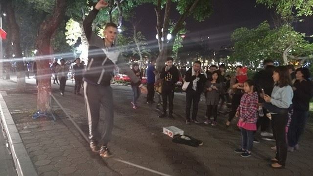 Người dân cả nước hân hoan trong phút giao thừa - 91
Một nghệ sỹ đường phố biểu diễn đi thăng bằng trên dây mua vui cho du khách.