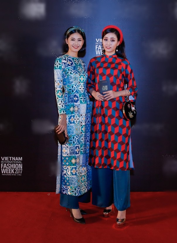 Chị em Á hậu Ngô Trà My và Ngô Thanh Thanh Tú cũng chọn áo dài đi xem thời trang gợi hình ảnh những cô gái thành thị đầy thanh lịch và quý phái. Nếu như Thanh Tú nữ tính với chiếc băng đô cài trên đầu thì Ngô Trà My đội thêm một chiếc mấn đỏ. Thiết kế áo dài của hai người đẹp được thiết kế riêng với hoạ tiết gạch bông mang hơi hướng hoài cổ.