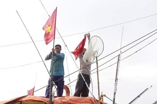 Tất niên trên tàu cá - 3
Ngư dân thay lá cờ Tổ quốc mới cho con tàu đón năm mới. Ảnh: Thanh Trần