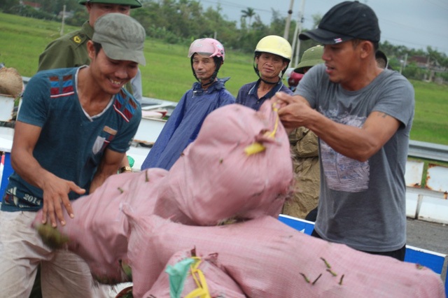 Trưởng công an xã đá văng thau cá và tàu đường sắt trên cao “dàn trận” chờ ngày lăn bánh - 2 Chiếc xe container đang di chuyển qua vòng xuyến đoạn đường tránh Cẩm Vịnh (xã Cẩm Vịnh, huyện Cẩm Xuyên, Hà Tĩnh) thì bất ngờ bị lật nghiêng, hàng tấn hoa quả tràn tóe ra giữa đường. Rất nhiều người dân đã cùng giúp tài xế gom nhặt lại số hoa quả. (Ảnh: Xuân Sinh)