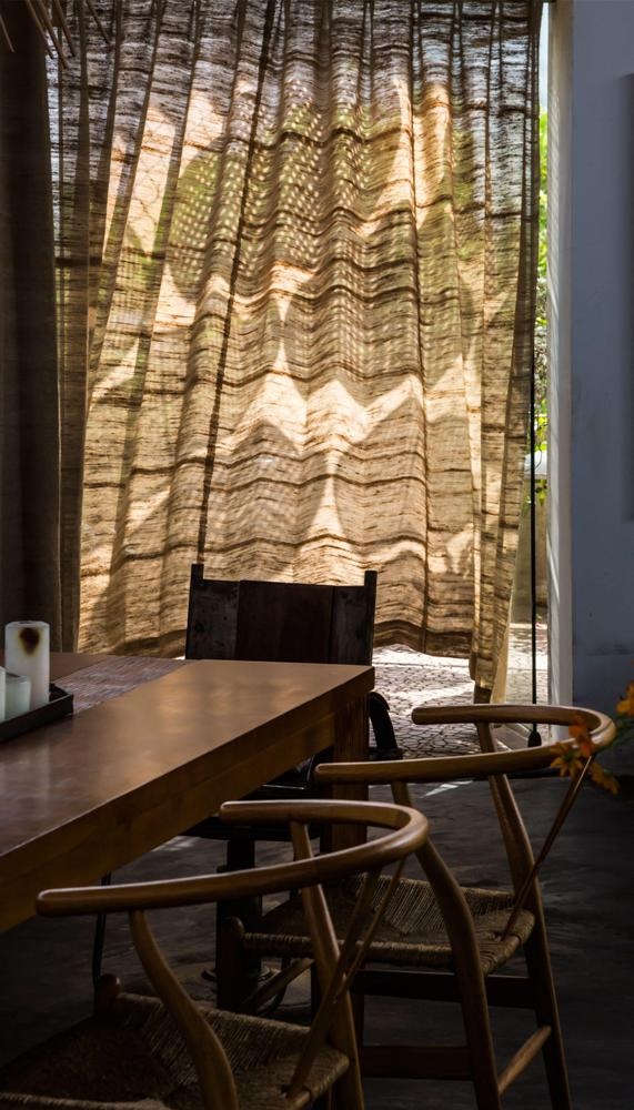 Giữa các không gian không sử dụng tường ngăn mà tận dụng những tấm rèm bằng chất liệu canvas, đủ dày để có sự riêng tư nhưng vẫn thoáng đãng, không bị bí như các chất liệu thông thường.