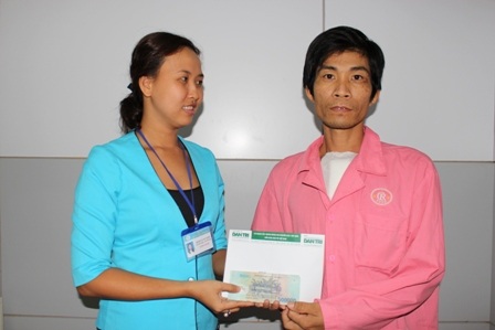 
Đại diện Phòng Công tác Xã hội, bệnh viện Chợ Rẫy trao tiền bạn đọc Dân trí ủng hộ cho anh Nhạn
