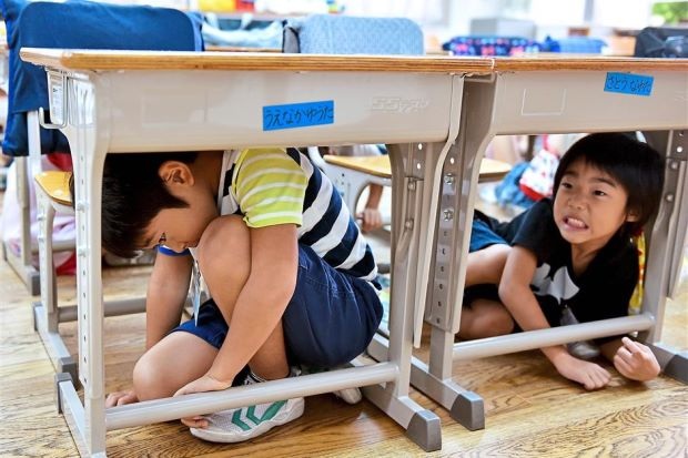 Nhật Bản phát cẩm nang hướng dẫn tự vệ khi bị Triều Tiên tấn công - 1 Trẻ em Nhật Bản học kỹ năng tự vệ khi xảy ra động đất (Ảnh: AFP)
