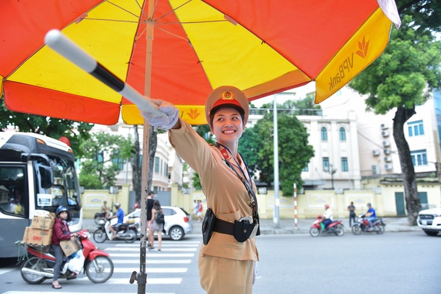Hàng chục cân tiền lẻ qua trạm BOT và "quái vật" đào 300m hầm xuyên lòng đất - 3 Đều đặn mỗi ngày, Thượng uý Lê Thị Thu Hà (Đội CSGT số 2, CATP Hà Nội) thức dậy từ hơn 5h sáng để kịp đi làm và chỉ trở về nhà sau 7h tối. Ngoài những lúc làm việc hành chính, nữ cảnh sát phải làm nhiệm vụ tại các điểm nóng giao thông bất kể thời tiết nắng mưa, gió rét. (Ảnh: Toàn Vũ)