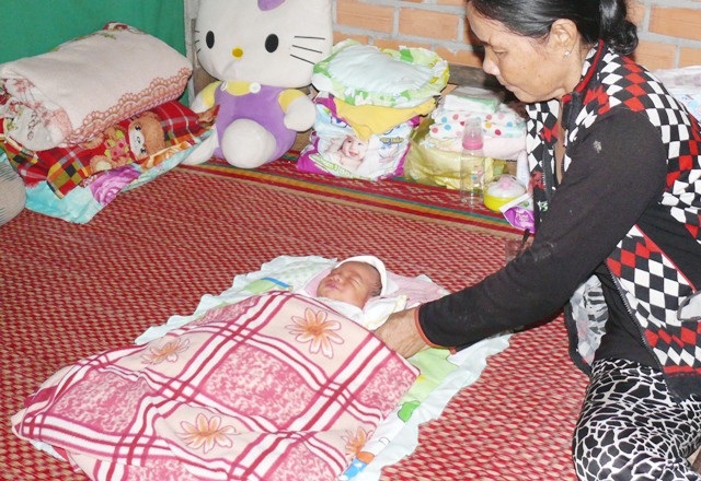 Bé trai sơ sinh bị bỏ rơi trong bụi rậm - 1 Cháu bé đang được một hộ dân chăm sóc. (Ảnh: CTV)
