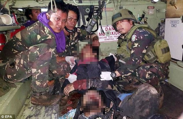 Trùm khủng bố khét tiếng nhất Đông Nam Á bỏ mạng vì cậu bé 16 tuổi - 3 Các binh sĩ Philippines công bố ảnh chụp thi thể của Hapilon và một thủ lĩnh phiến quân khác tại Marawi (Ảnh: EPA)