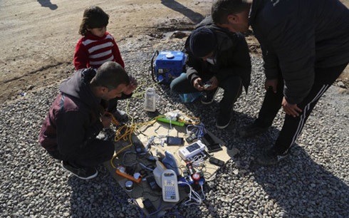 Người tị nạn Iraq đang nạp điện cho điện thoại di động với giá 500 dinar tại trại Sewdinan. Ảnh: AP.