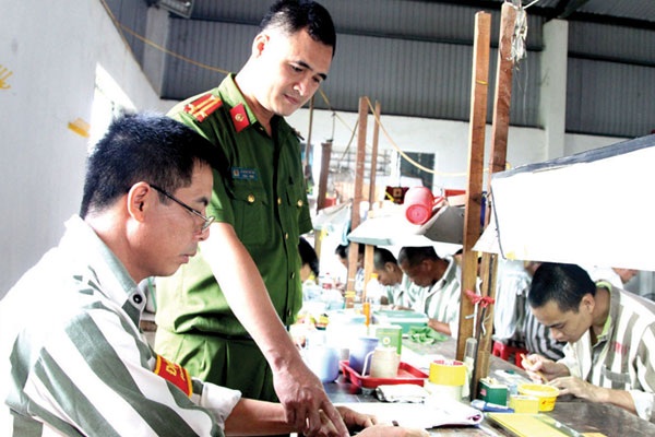 Tình người quản giáo - 1 Trung tá Lê Ngọc Quỳnh hướng dẫn phạm nhân tại xưởng sản xuất.