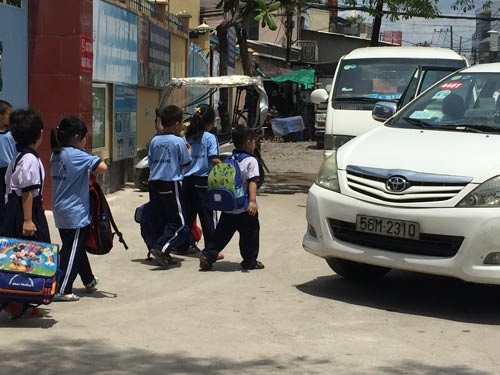 Học một buổi, học sinh biết về đâu? - 1 Vừa tan học, từng nhóm học sinh của Trường Tiểu học Đặng Thị Rành (quận Thủ Đức) lên taxi đợi sẵn để về nhà giáo viên ăn, học buổi 2.