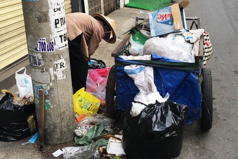 Bà Đặng Thị Đàn tìm phế liệu trong đống rác. Ảnh: Trần Chánh Nghĩa