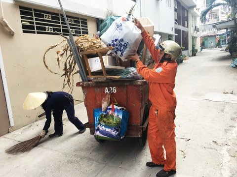 Ngày mồng một Tết của những người 'quên' giao thừa - 1 Chưa đến ca, anh Thắng đã phụ chị Phượng thu gom rác