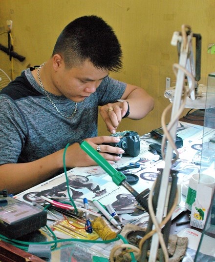 Nghề sửa máy ảnh - Vinh quang và tàn lụi - 2 Nghĩa (quê Nam Định) đang sửa máy ảnh tại TPHCM.
