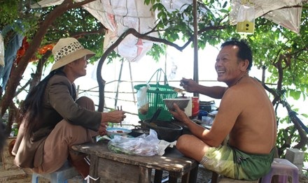 Phóng sự: Về làng cũ - 2 Bữa cơm ngập tiếng cười của vợ chồng ông Em - bà Liễu trước căn chòi nhỏ. Ảnh: Thanh Trần.